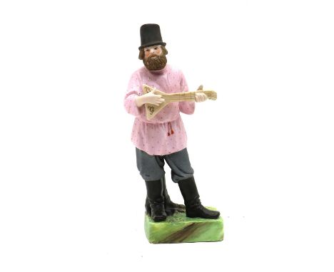 A Russian Gardner Factory biscuit porcelain figure, of a man playing the Balalaika, impressed and red printed marks, 21.5cm h