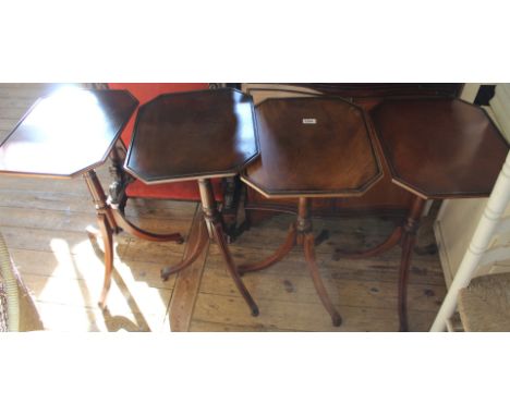 A set of four reproduction mahogany tripod wine tables