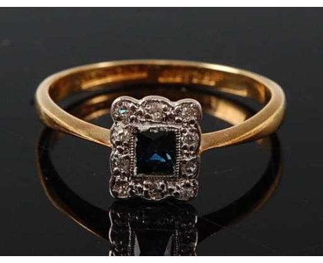 A yellow and white metal, sapphire and diamond rectangular cluster ring, featuring a centre rectangular cut sapphire within a