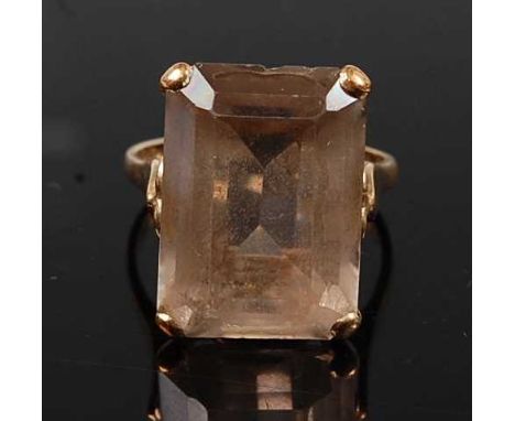 A 9ct yellow gold topaz single stone ring, having a rectangular cut brown topaz in a four-claw setting with pierced heart sha