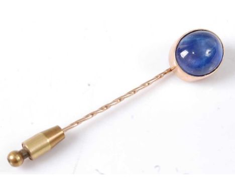 A yellow metal sapphire stick pin, featuring an oval cabochon cut star sapphire in a bead setting, sapphire dimensions approx