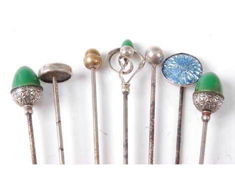 Seven assorted white metal hat pins to include two carved as acorns with green top, one carved in a scrollwork flower design 