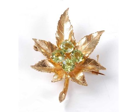 A 9ct yellow gold Maple leaf brooch, having a quatrefoil of round faceted peridot in the centre and a roller catch fastening,