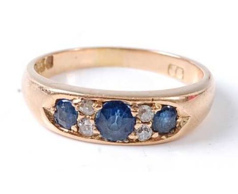 An Edwardian 18ct yellow gold sapphire and diamond dress ring comprising three graduated oval faceted sapphires with two old 