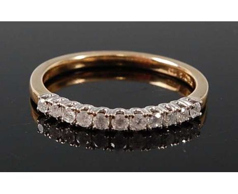 A 9ct yellow and white gold diamond half hoop eternity ring, comprising eleven round brilliant cut diamonds in claw settings,