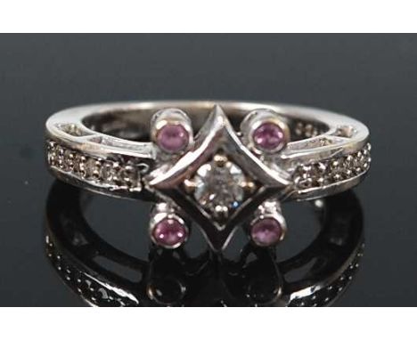 An 18ct white gold, diamond and pink sapphire quatrefoil cluster ring, featuring a centre round brilliant cut diamond in an o