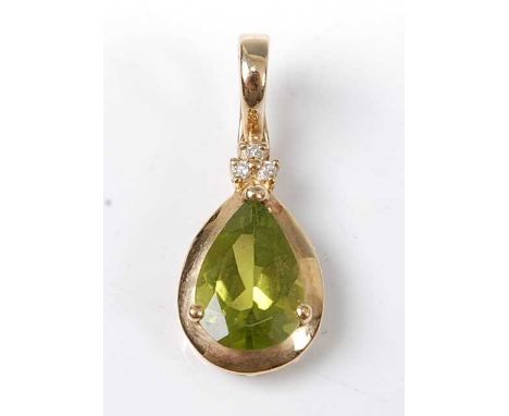 A 9ct yellow gold, peridot and diamond pendant, featuring a pear cut peridot in a claw and bezel setting, suspended below a t