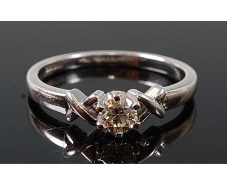 An 18ct white gold diamond single stone ring, featuring a round brilliant cut diamond in a six-claw setting, with cross detai