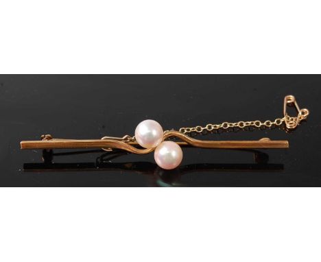 A 9ct yellow gold pearl bar brooch, featuring two 7.1mm cultured pearls in a crossover style, with roller catch fastening and