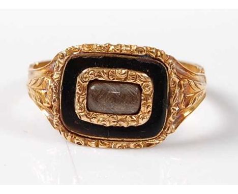 A yellow metal Georgian memorial ring, featuring a centre rectangular panel with braided hair within a black enamel border, w