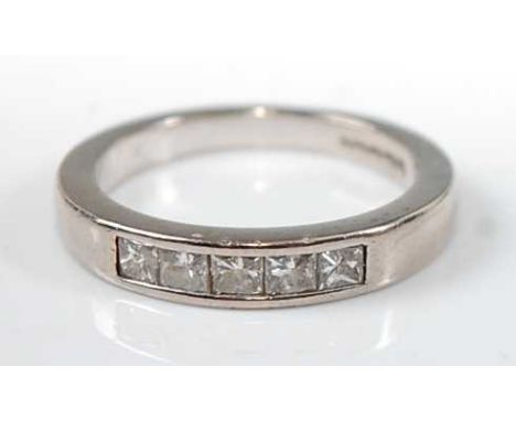 An 18ct white gold diamond half hoop eternity ring, with five Princess cut diamonds in channel settings, diamond dimensions e