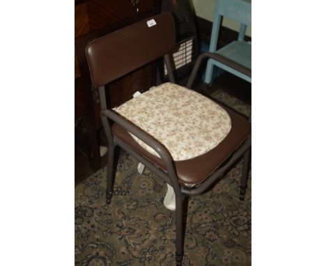 A modern mobility commode chair, with metal frame and leatherette back and seat.