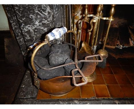 A copper coal bucket, a set of brass fire implements, toasting fork and poker.