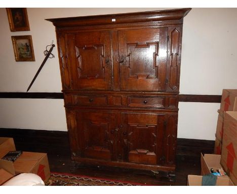 An early 17thC oak press cupboard, with cushion moulded cornice, the upper part having two fielded panel doors with the singl