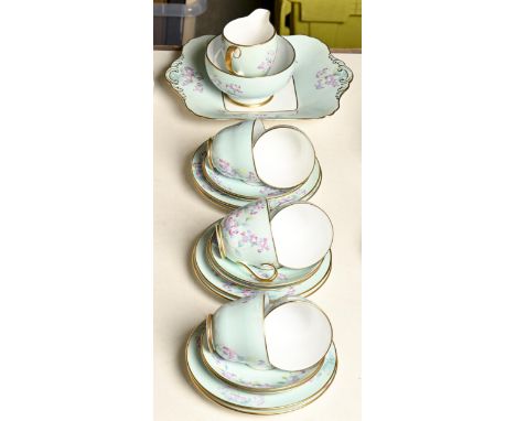 A Copeland bone china tea service, 1937, printed and painted with flowers on a light blue ground, the rims and handles gilt, 