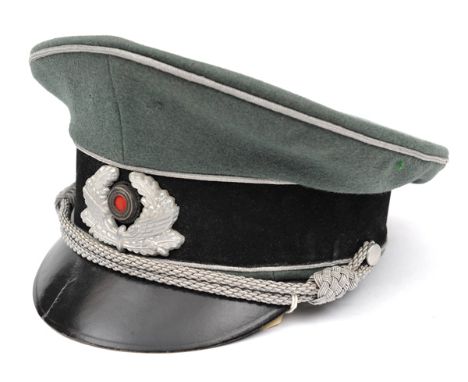 A Third Reich Army officer’s type peaked cap, with green top, black band, fibre peak and silver bullion cords and piping, and