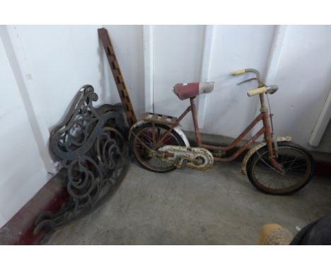 A pair of rocking garden bench ends and a vintage Sunbeam child's bicycle 