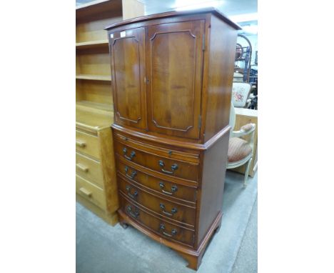 A yew wood bow front cupboard on chest 