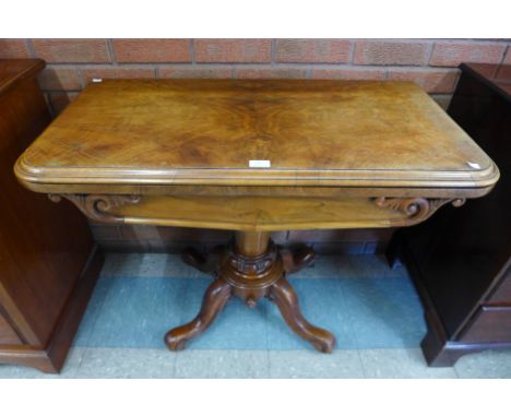 A Victorian walnut fold over card table 