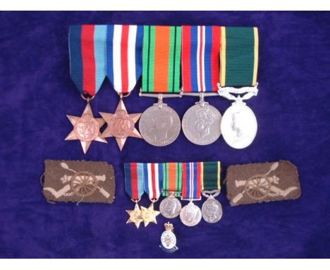 A WWII group of four and a Territorial Efficient Service Medal to R W Golding R A:, and matching miniatures (unnamed replacem