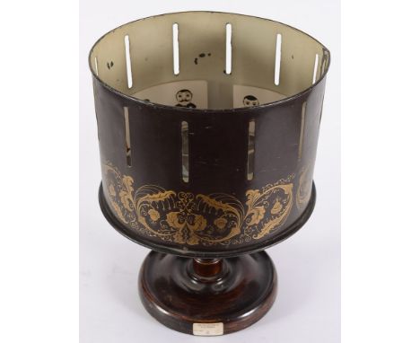An early 20th century brown and gilt Russian lacquer Zoetrope:. the 25cm rotating drum on a turned support and circular base,