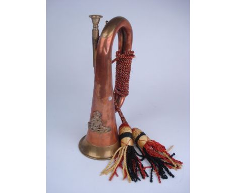 A copper and brass Royal Artillery bugle:, of typical form with applied crest to bell and coloured bullion loop, 26.5cm high.