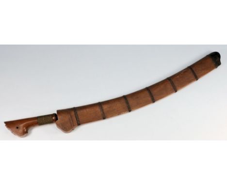 A South East Asian Kris style sword: with 51cm. curved single edged blade, shaped wood grip, contained in a wood and leather 