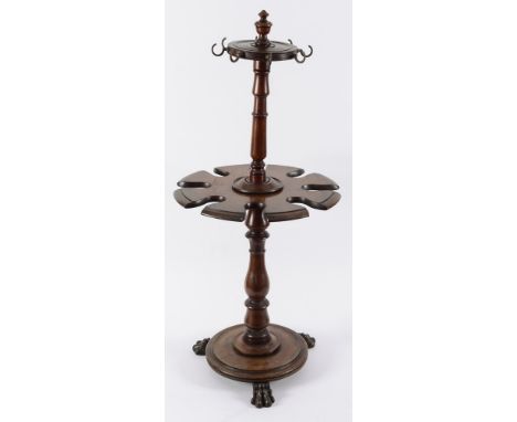 A 19th century mahogany rotating boot and crop stand surmounted by an urn shaped finial raised on turn column support on a ci