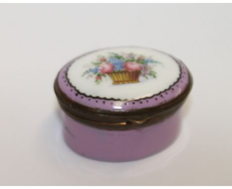 18th century English enamel patch box of oval form, pink ground with a basket of flowers to the hinged mirrored cover, 4cm  w