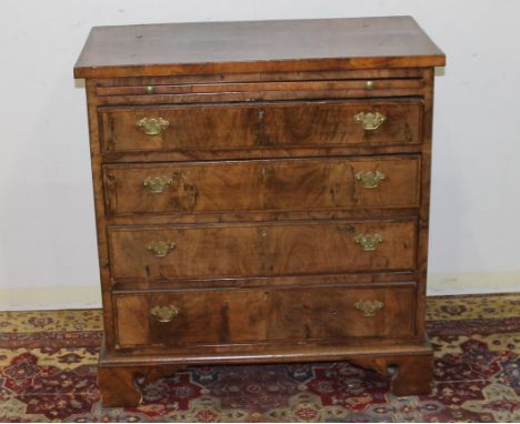 Early 18th century walnut chest, the rectangular top with edge moulding above brushing slide and four graduated drawers on br
