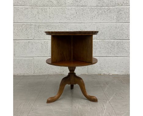 A Georgian walnut bookcase table of revolving barrel form having a circular piecrust tray top over four recessed compartments