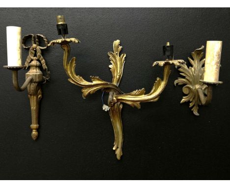 A collection of three 19th century and later gilt metal wall sconces to include one with a scrolling Rococo style backplate a