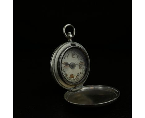An early 20th century military issue pocket compass with a white, black and red dial in a polished steel surround possibly by
