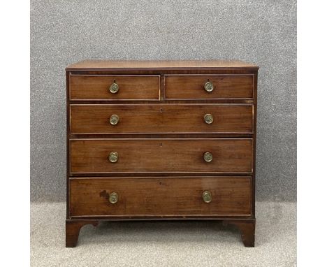 A Georgian mahogany and crossbanded chest of drawers having a rectangular top with a reeded edge above two short over three l