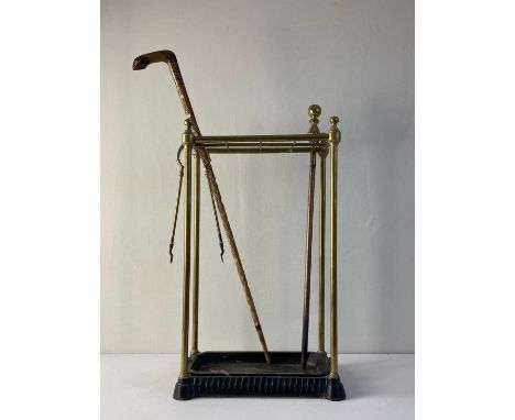 A C.1900 stick stand having a tubular brass superstructure with a gridded top and turned finials raised on a cast iron plinth