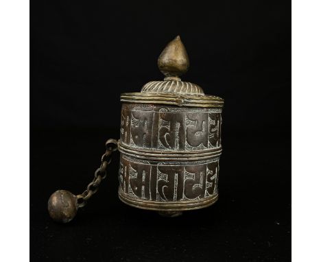 A 19th century hand forged and decorated Tibetan Buddhist prayer wheel or windmill having a brass cover with finial over an e