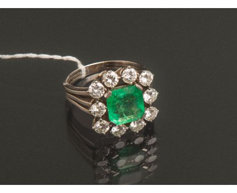 Damenring mit Edelsteinbesatz 750 WG, mittig besetzt m. 1 Smaragd im Emerald Cut (ca. 9 x9 mm), darum 10 Diamanten im Brillan