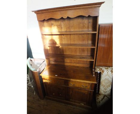 An oak shelf back dresser upon a two drawer two door base