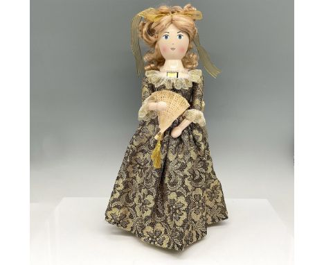 Lady nutcracker in gold brocade dress with gold lace ribbon tie, holding a fan and wearing an iridescent necklace. Lord &amp;