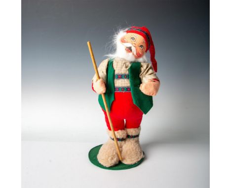 Santa sporting a rugged red, green, and tan hiking ensemble, complete with a large walking stick for traveling. Annalee manuf