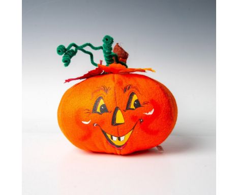 A jack o lantern radiating warmth with its smile and glowing yellow eyes and adorned with festive leaves and stems atop its h