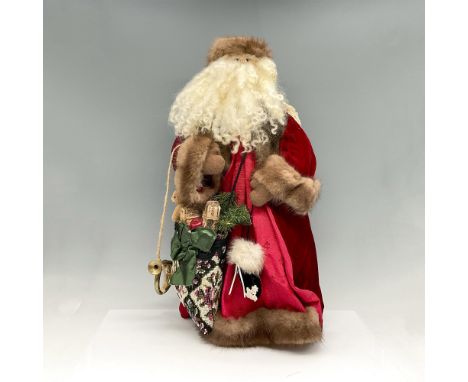 Full beard, fur hat, long coat with fur trim carrying bag of gifts and his horn to announce his arrival. Wonderfully detailed