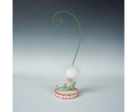 Hand painted glittery Christmas decoration. Depicts on a red and white base, on top a green and red elf-like heel with a whit