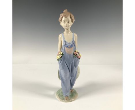 Glossy figurine of a young child wearing overalls with pockets that are full of delicate colorful flowers and holding a wide 