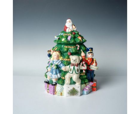 A colorful ceramic hand painted jar and lid in the shape of a decorated Christmas tree with Santa Claus sitting at the top an