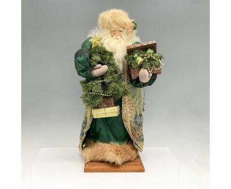 Hand crafted Santa with extreme detail in the clothing to the aspects of the character. Dressed in tapestry long coat holding