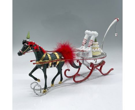 Glittery Christmas display of a green horse decked out in gold straps and red feathers pulling a silver ladle sleigh. Sleigh 