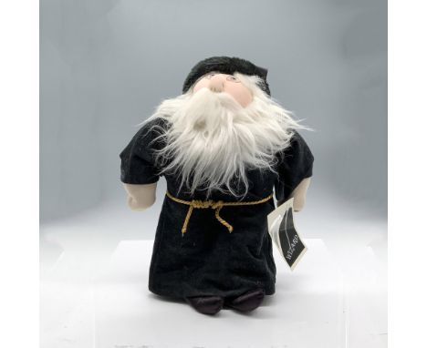 A soft sculpture of a wizard wearing a long black robe with a gold-colored rope belt and a black satin hat. Xavier Roberts si