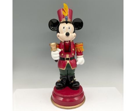 Wooden figure dressed in his parade gear, red top hat with feather, coat with gold shoulder ornamental epaulettes and green p
