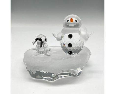 Whimsical faceted crystal figurine modeled as a smiling snowman with his arms wide. Black buttons, orange nose. Satin crystal